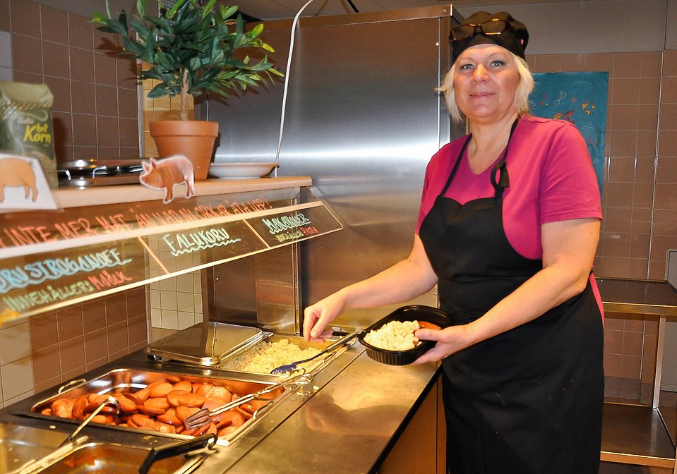 Ann-Christin Helén, kock på Mora gymnasiums kök, fyller sin matlåda med mat.